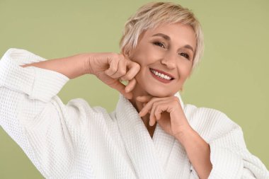 Yeşil arka planda masaj yapan olgun kadın, yakın plan.