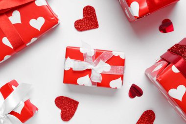 Kalpli hediye kutuları ve beyaz arka planda konfeti. Sevgililer Günü kutlaması