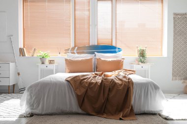 Büyük yataklı, masalı ve pencereli aydınlık yatak odasının içi