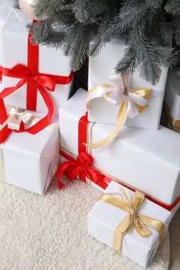 Oturma odasındaki Noel ağacının altında hediye kutuları