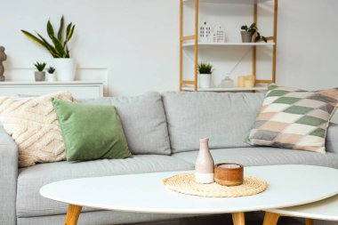 Oturma odasındaki kahve masasında mumlu vazo.