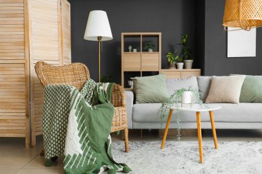 Modern oturma odasının içinde bitkiler, kanepe ve koltuk var.