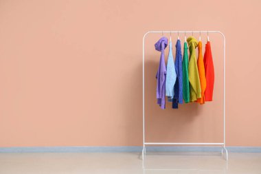 Renkli kazaklarla renk duvarının yanında dizilin