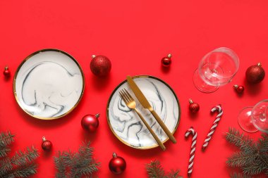 Kırmızı arka planda Noel süslemeleri olan şenlik masası.