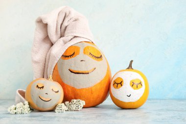 Maskeli balkabakları ve grunge masasında çiçekler.