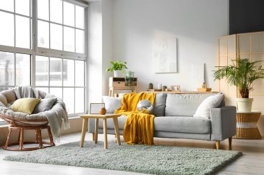 Gri kanepe, koltuk ve sehpa üzerinde disko topu olan modern oturma odasının içinde.