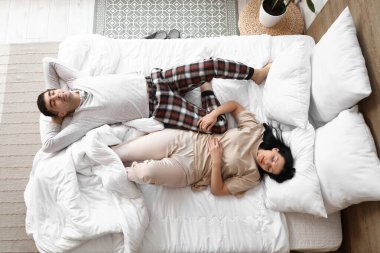 Yatak odasında uyuyan genç bir çift.