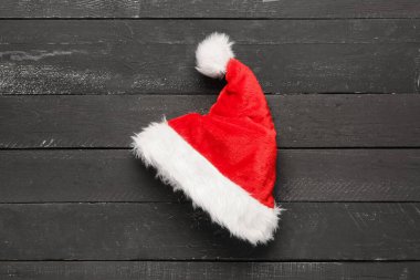 Siyah ahşap arka planda Noel Baba şapkası