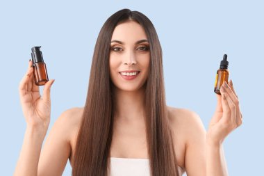 Mavi arka planda saç ürünleri olan genç esmer kadın, yakın plan.