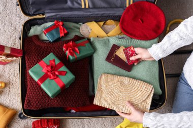 Kadın valizine, elbiselerine, belgelerine ve Noel hediyelerine, yakın plan.