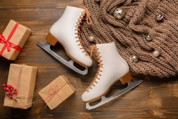 Коньки с рождественскими шарами и подарочные коробки на деревянном фоне