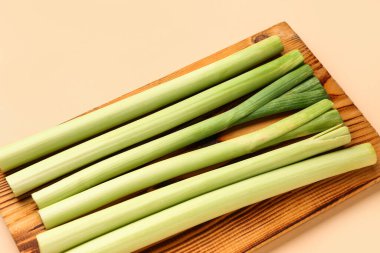 Bej arkaplanda taze pırasa olan tahta