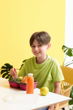 Küçük çocuk okulda öğle yemeği yiyor.