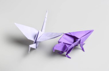 Renkli origami dinozor ve gri arkaplanda vinç