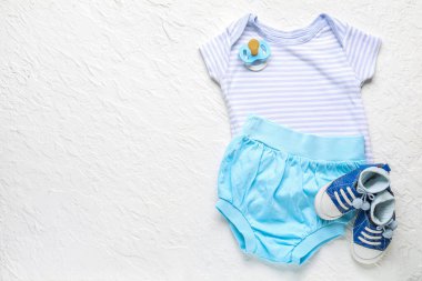 Şık bebek kıyafetleri ve açık arkaplanda aksesuarları olan kompozisyon