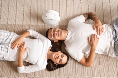 Elektrik vantilatörlü genç bir çift yerde yatıyordu.