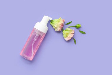 Renkli arka planda güzel çiçekler ve kozmetik ürünler içeren kompozisyon