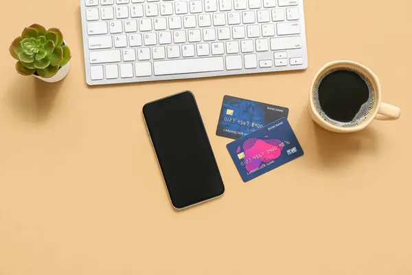 Telefon Komórkowy Kartami Kredytowymi Filiżanką Kawy Klawiaturą Komputerową Beżowym Tle — Zdjęcie stockowe