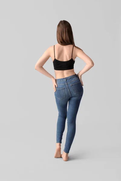 Body positive woman on light background, back view