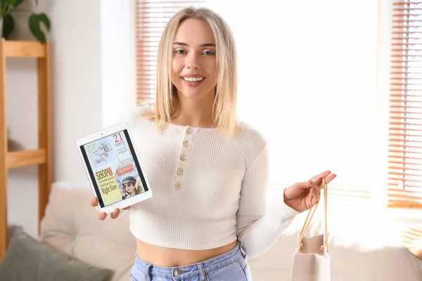 Young woman with tablet and bag shopping online at home