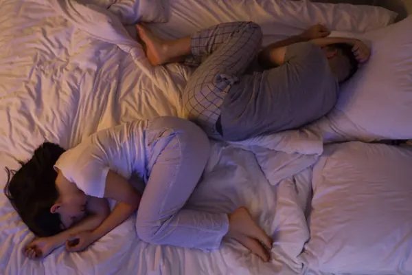 Young couple sleeping in bedroom at night, top view