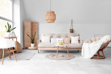 Beyaz kanepesi, koltuğu ve kahve masası olan bir oturma odası.