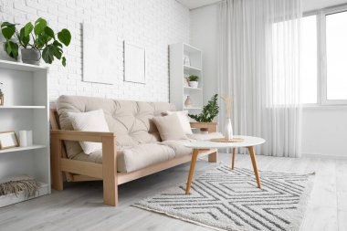 Rahat kanepesi, çiçekleri ve beyaz mobilyaları olan aydınlık oturma odasının içinde.