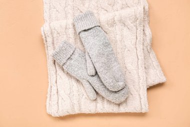 Bej arka planda sıcak eşarplı bir çift örgü eldiven