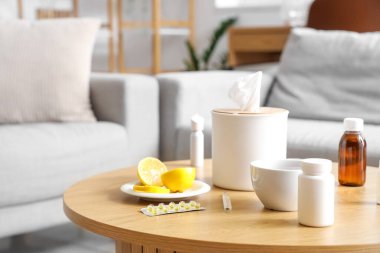 Oturma odasındaki masada limon ve mendil kutusu olan ilaçlar.