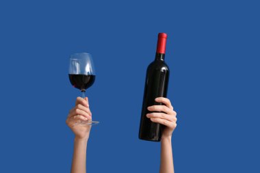 Arka planda şarap ve cam şişesi olan kadın elleri.