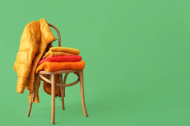 Yeşil arka planda, üzerinde ceket olan kazaklar yığıldı.