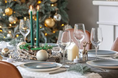 Noel süslemeleri ve yanan mumlarla güzel bir masa, yakın plan.