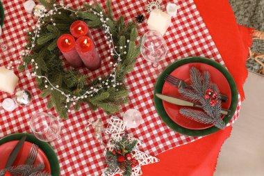 Noel sofrasında yanan mumlar ve çelenkler.