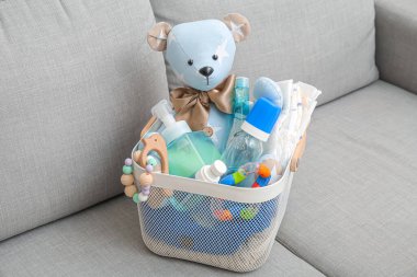 Odadaki kanepede bebek için hediye sepeti.
