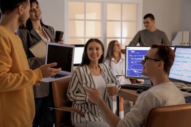 Akşam ofiste çalışan genç programcılardan oluşan bir ekip.