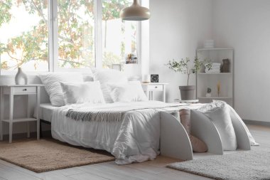 Büyük yataklı ve masalı bir otel odası.