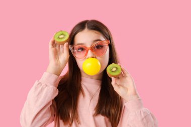 Pembe arka planda sakız sakızı üfleyerek moda olan kız.