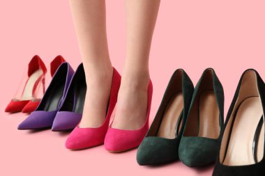 Pembe arka planda farklı yüksek topuklu güzel genç bayanların bacakları.