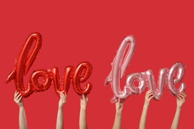 Balonlu kadın elleri kırmızı arka planda aşk sözcükleri. Sevgililer Günü kutlaması