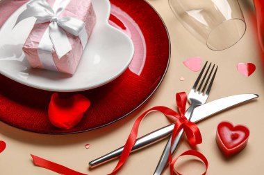 Bej arkaplanda mum, hediye ve dekorla Sevgililer Günü için güzel bir masa.