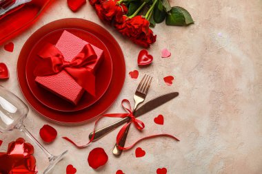 Sevgililer Günü için güzel bir masa, şarap şişesi, kırmızı güller ve bej rengi grunge arka planda dekor.