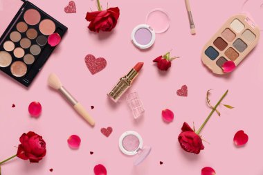 Kırmızı güllü kozmetik ürünler ve pembe arka planda kalpler. Sevgililer Günü kutlaması