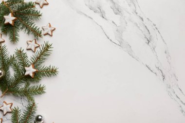 Lezzetli yıldızlar, beyaz grunge arka planında köknar dalları olan Noel kurabiyeleri şekillendirdiler.