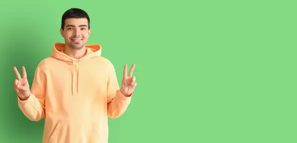 Young Man Showing Victory Gesture Green Background Space Text — Stock Photo, Image