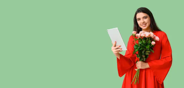 Happy young woman with tablet computer and rose flowers on green background with space for text