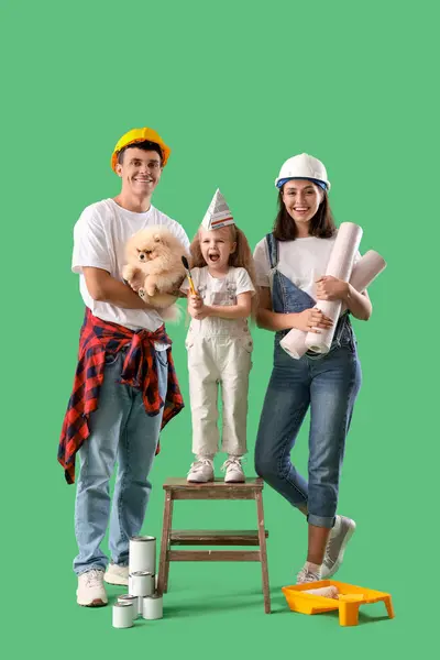 Happy family with repair materials on green background