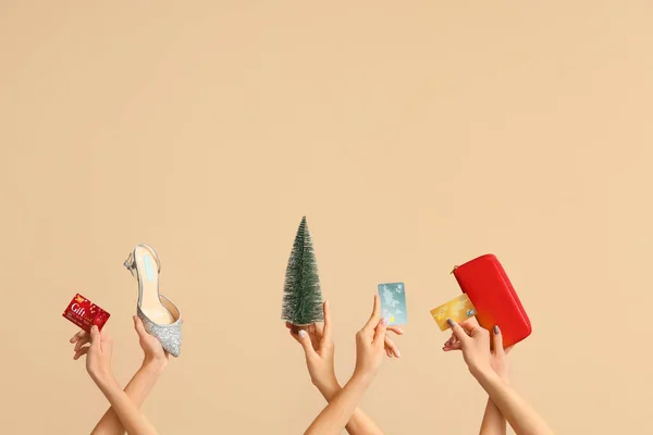 Female hands with credit cards, wallet and shoe on beige background. New year shopping concept