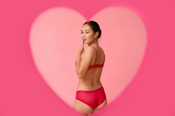 漂亮的年轻亚洲女人穿着性感内衣 从粉色背景的心形孔中可以看到 情人节庆祝活动 — 图库照片