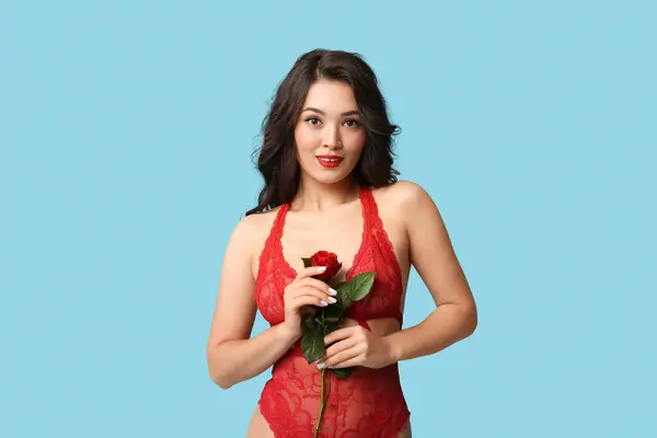 快乐的年轻亚洲女人 穿着性感内衣 蓝色背景的美丽玫瑰 — 图库照片