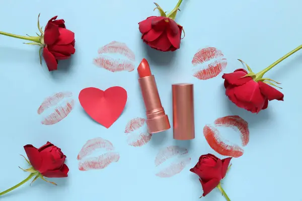 Lipstick with kisses and red roses on blue background